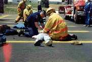 A Michigan State Police officer bags the victim while a firefighter does compressions.